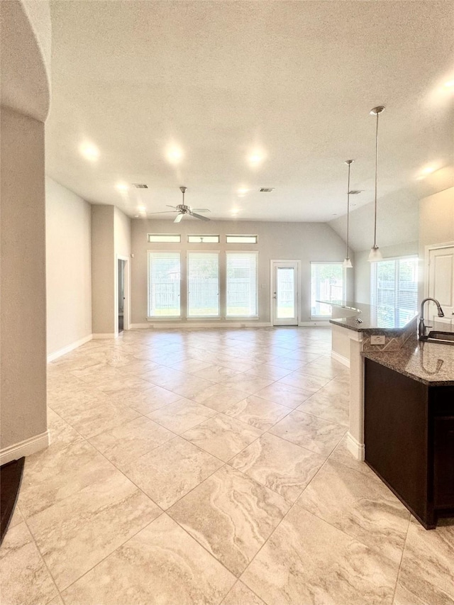 29018 Pinnacle Ridge Dr, Katy, TX 77494 - kitchen with a ceiling fan, open floor plan, a textured ceiling, dark stone countertops, and pendant lighting