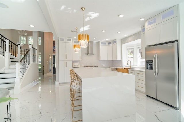 5515 E Terrace Gable Cir, Katy, TX 77494 - kitchen featuring appliances with stainless steel finishes, wall chimney range hood, a chandelier, a kitchen island, and recessed lighting