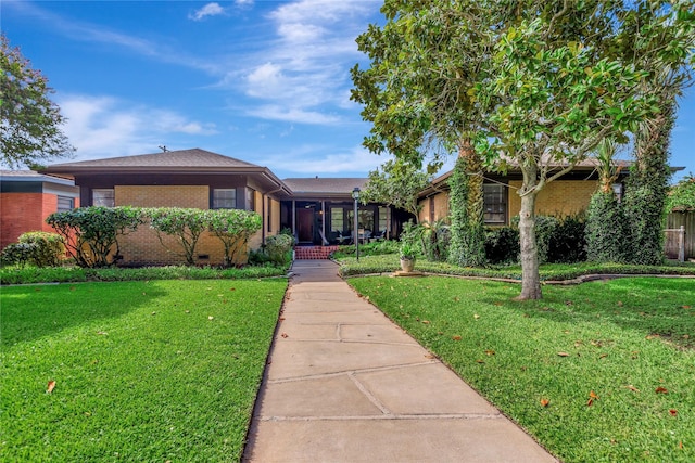 4316 Caduceus Pl, Galveston, TX 77550 - view of front facade featuring brick siding, a front yard, and crawl space