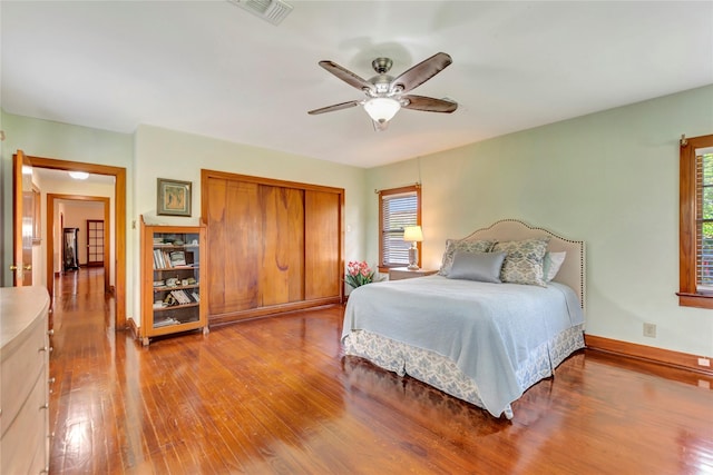 4316 Caduceus Pl, Galveston, TX 77550 - bedroom featuring multiple windows, hardwood / wood-style floors, a closet, and a ceiling fan
