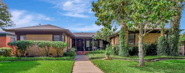 4316 Caduceus Pl, Galveston, TX 77550 - view of front of house with brick siding and a front yard