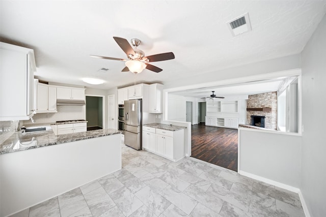 11607 Knobcrest Dr, Houston, TX 77070 - kitchen featuring appliances with stainless steel finishes, a ceiling fan, light stone countertops, and open floor plan