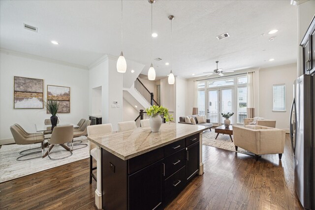 1124 W 24th St Unit B, Houston, TX 77008 - kitchen with freestanding refrigerator, a kitchen breakfast bar, ornamental molding, open floor plan, and dark cabinets