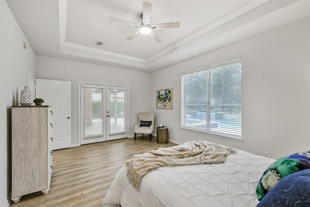 8006 Sports Haven Dr, Humble, TX 77346 - bedroom featuring a tray ceiling, access to outside, light wood-style floors, crown molding, and french doors