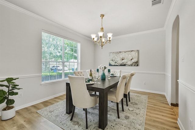 8006 Sports Haven Dr, Humble, TX 77346 - dining room featuring arched walkways, a chandelier, ornamental molding, and light wood-style flooring