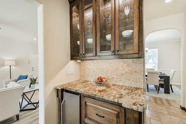 8006 Sports Haven Dr, Humble, TX 77346 - bar featuring arched walkways, stainless steel fridge, ornamental molding, tasteful backsplash, and recessed lighting