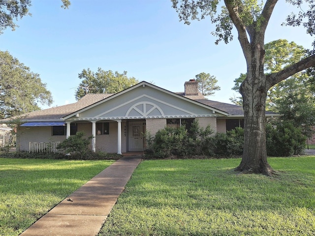 7807 Bellerive Dr, Houston, TX 77036 - view of front of house with a front yard, brick siding, a chimney, and covered porch
