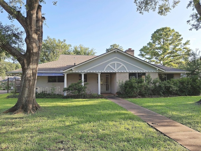 7807 Bellerive Dr, Houston, TX 77036 - view of front of home with a front lawn, a chimney, brick siding, and covered porch