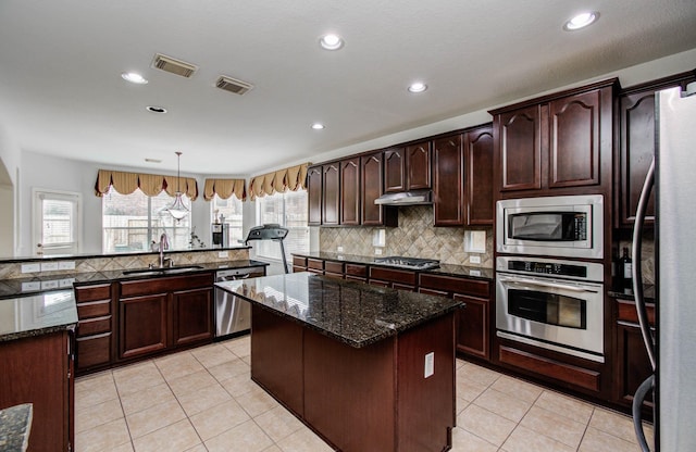 11704 Shoal Lndg, Pearland, TX 77584 - kitchen featuring appliances with stainless steel finishes, a kitchen island, tasteful backsplash, recessed lighting, and light tile patterned flooring