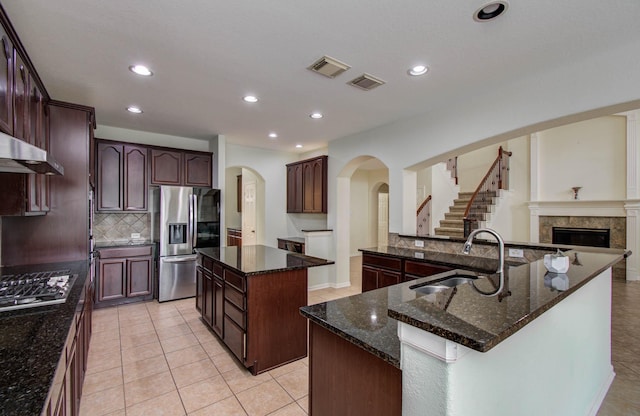 11704 Shoal Lndg, Pearland, TX 77584 - kitchen with stainless steel appliances, a large island, arched walkways, decorative backsplash, and recessed lighting
