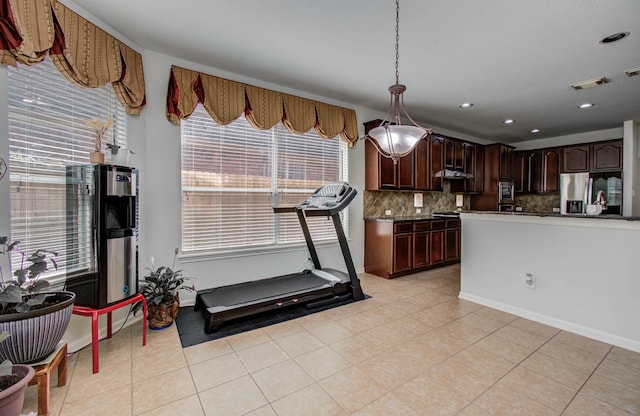 11704 Shoal Lndg, Pearland, TX 77584 - kitchen featuring appliances with stainless steel finishes, backsplash, light tile patterned floors, under cabinet range hood, and dark countertops