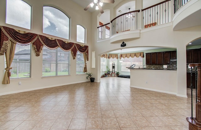 11704 Shoal Lndg, Pearland, TX 77584 - unfurnished living room featuring plenty of natural light, ceiling fan, light tile patterned floors, and a towering ceiling