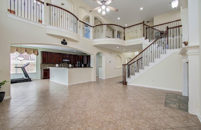 11704 Shoal Lndg, Pearland, TX 77584 - unfurnished living room with ceiling fan, stairway, a high ceiling, recessed lighting, and arched walkways