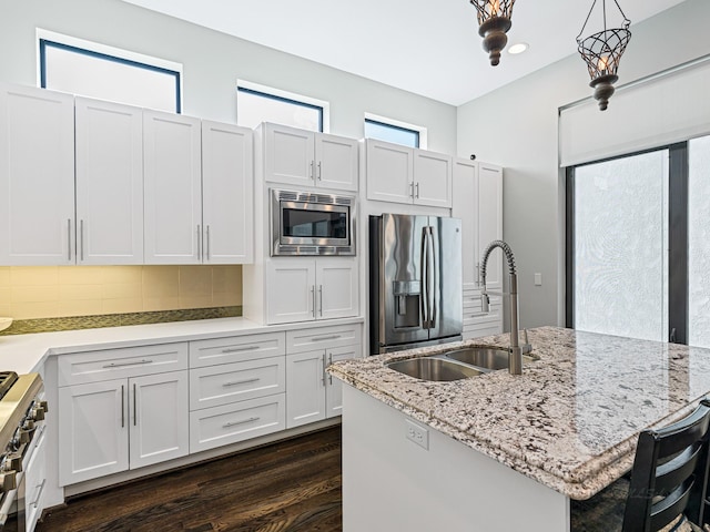 1520 Malone St, Houston, TX 77007 - kitchen featuring stainless steel appliances, tasteful backsplash, light stone countertops, dark wood finished floors, and a center island with sink