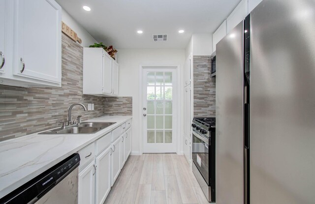 12407 Big Oaks Dr, Houston, TX 77050 - kitchen with stainless steel appliances, white cabinetry, decorative backsplash, recessed lighting, and light stone countertops
