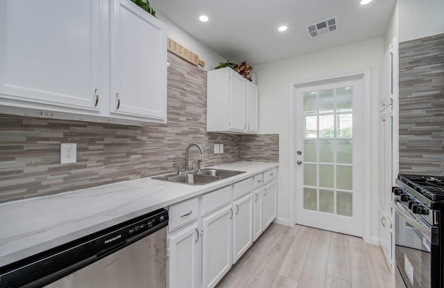 12407 Big Oaks Dr, Houston, TX 77050 - kitchen with appliances with stainless steel finishes, white cabinetry, decorative backsplash, light wood-style floors, and recessed lighting