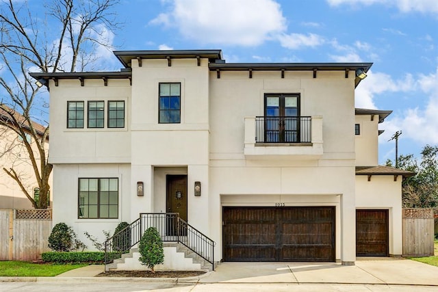 8015 Serenity Ct, Houston, TX 77025 - view of front facade featuring an attached garage, a balcony, stucco siding, and driveway