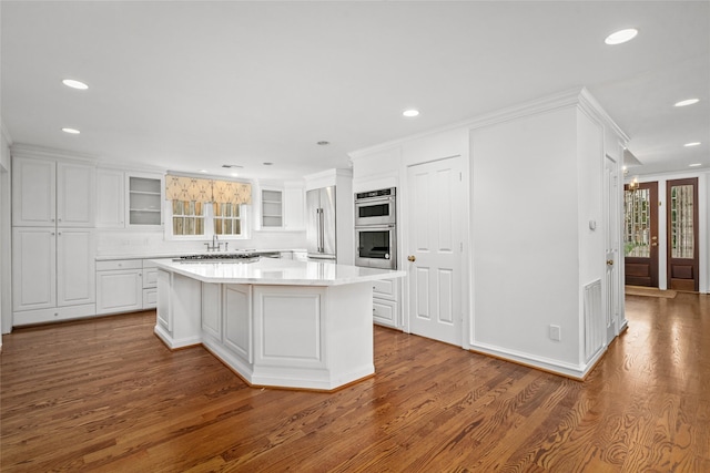 2105 Del Monte Dr, Houston, TX 77019 - kitchen featuring white cabinetry, stainless steel appliances, wood finished floors, recessed lighting, and ornamental molding