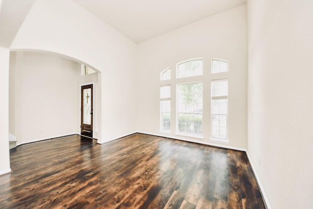 6902 Sterling Meadow Dr, Katy, TX 77449 - spare room featuring arched walkways, dark wood-style flooring, and a high ceiling