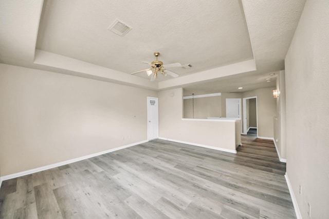 6902 Sterling Meadow Dr, Katy, TX 77449 - spare room with a tray ceiling, wood finished floors, a ceiling fan, and a textured ceiling