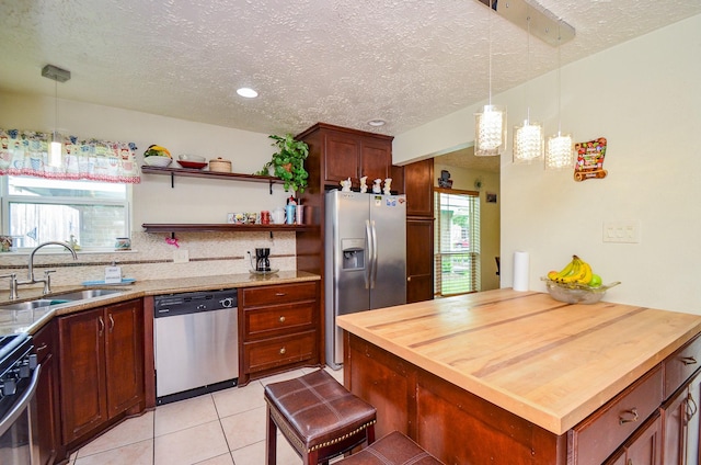 4318 Glen Avon Dr, Pasadena, TX 77505 - kitchen with stainless steel appliances, wood counters, plenty of natural light, a textured ceiling, and light tile patterned floors