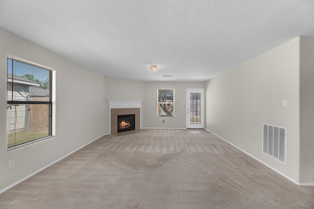 16810 Perryton Ln, Houston, TX 77073 - unfurnished living room featuring light carpet, a fireplace, and a textured ceiling
