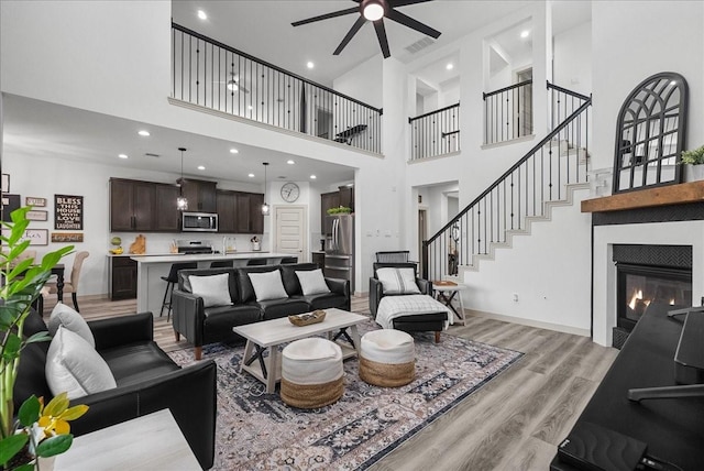 6214 Bois D Arc St, League City, TX 77573 - living area featuring ceiling fan, light wood finished floors, a high ceiling, a glass covered fireplace, and recessed lighting