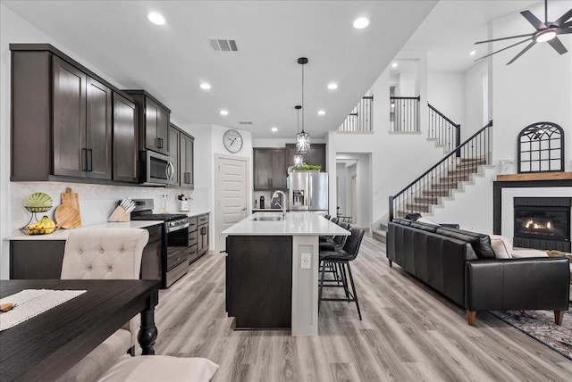 6214 Bois D Arc St, League City, TX 77573 - kitchen with stainless steel appliances, open floor plan, a kitchen breakfast bar, light countertops, and dark brown cabinets
