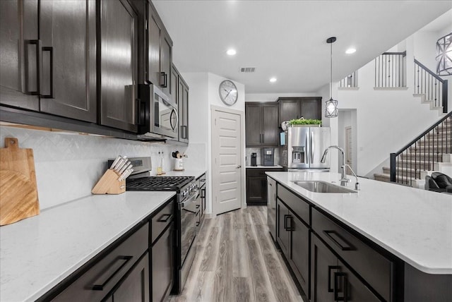 6214 Bois D Arc St, League City, TX 77573 - kitchen featuring stainless steel appliances, light wood-style flooring, decorative backsplash, decorative light fixtures, and recessed lighting