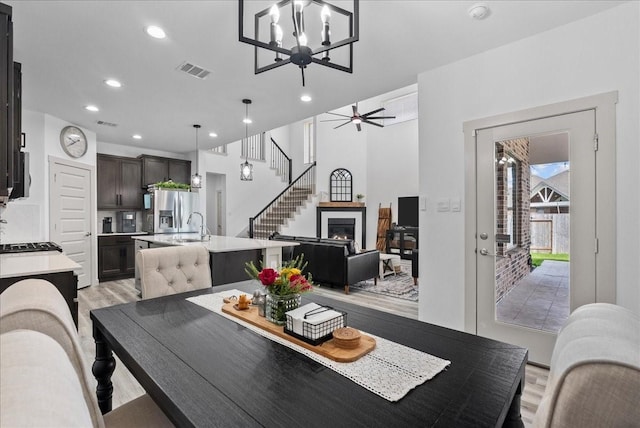 6214 Bois D Arc St, League City, TX 77573 - dining space with light wood finished floors, recessed lighting, a chandelier, stairs, and a ceiling fan