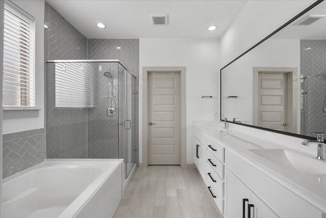 6214 Bois D Arc St, League City, TX 77573 - bathroom with plenty of natural light, a bath, double vanity, a stall shower, and recessed lighting