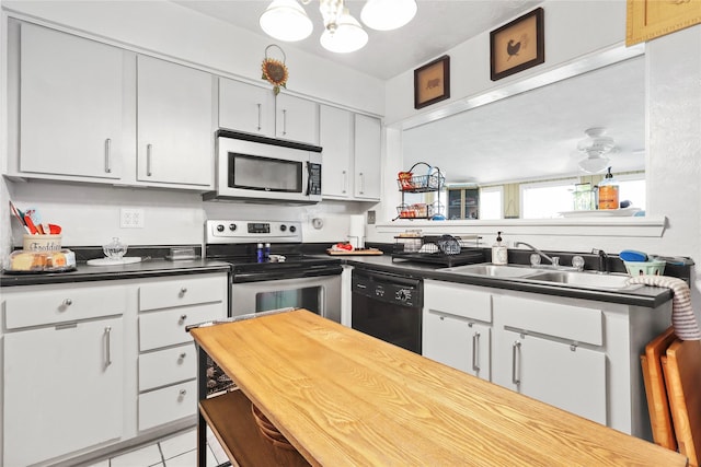 826 Ivyhollow Dr, Channelview, TX 77530 - kitchen featuring stainless steel appliances, a chandelier, light tile patterned flooring, white cabinets, and butcher block counters
