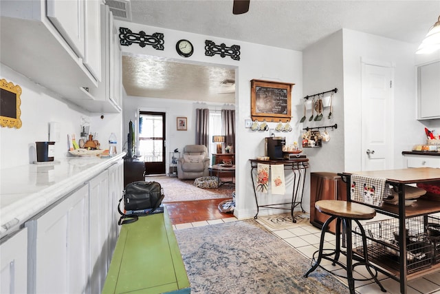 826 Ivyhollow Dr, Channelview, TX 77530 - kitchen with white cabinetry, a textured ceiling, ceiling fan, and light tile patterned floors