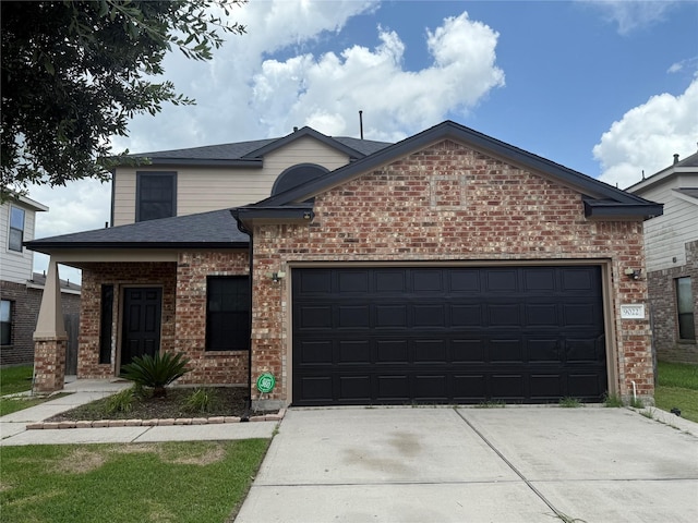 9022 Saint Laurent Ln, Houston, TX 77044 - view of front of house with brick siding, an attached garage, driveway, and roof with shingles