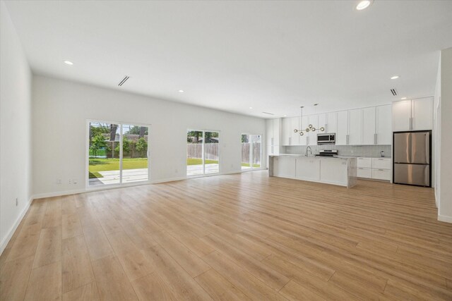 10225 Shadow Oaks Dr, Houston, TX 77043 - unfurnished living room with light wood-type flooring and recessed lighting