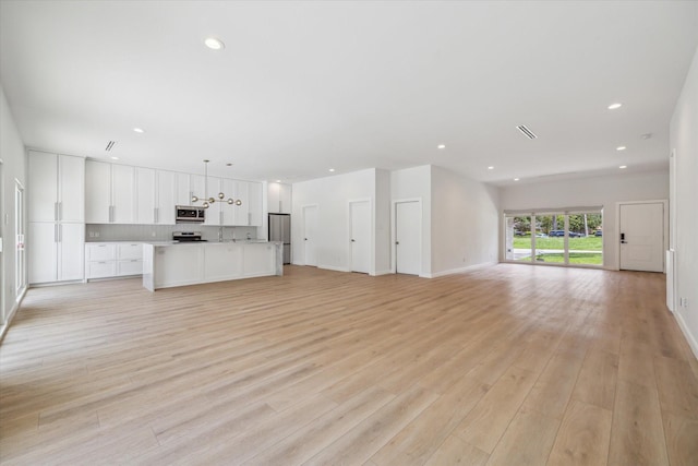 10225 Shadow Oaks Dr, Houston, TX 77043 - unfurnished living room featuring light wood-type flooring and recessed lighting
