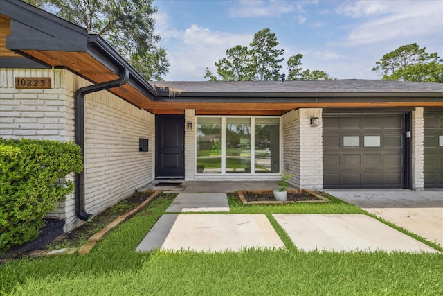 10225 Shadow Oaks Dr, Houston, TX 77043 - entrance to property featuring brick siding, an attached garage, and concrete driveway