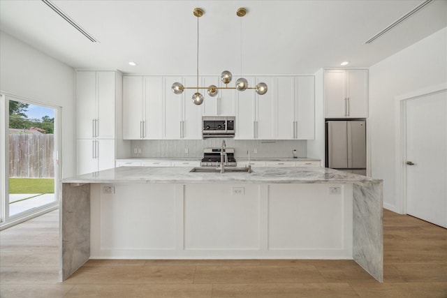 10225 Shadow Oaks Dr, Houston, TX 77043 - kitchen featuring stainless steel appliances, white cabinets, a large island, light stone counters, and recessed lighting
