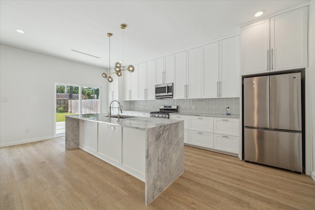 10225 Shadow Oaks Dr, Houston, TX 77043 - kitchen featuring appliances with stainless steel finishes, light wood finished floors, white cabinets, and recessed lighting