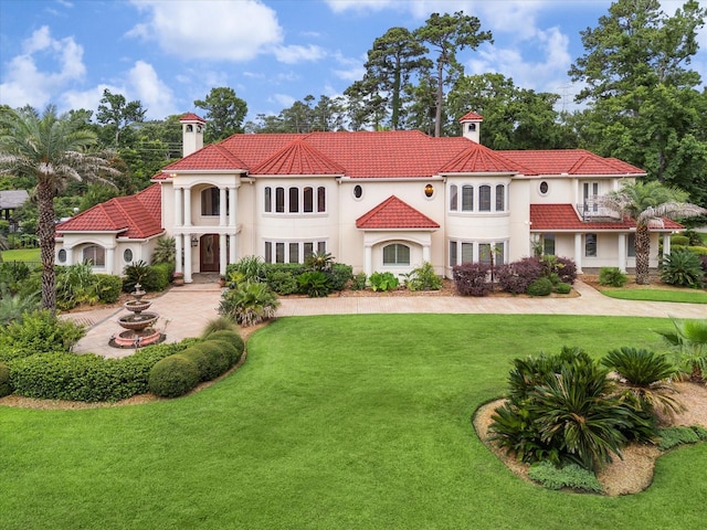 6 Kings Lake Estates Blvd, Kingwood, TX 77346 - mediterranean / spanish-style house with a chimney, a front lawn, stucco siding, and a tiled roof