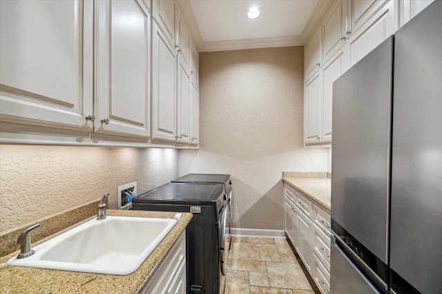 6 Kings Lake Estates Blvd, Kingwood, TX 77346 - laundry room featuring a textured wall, washer and dryer, light stone finish flooring, ornamental molding, and cabinet space