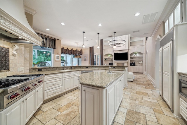 6 Kings Lake Estates Blvd, Kingwood, TX 77346 - kitchen featuring stainless steel gas cooktop, custom exhaust hood, stone tile floors, recessed lighting, and a peninsula
