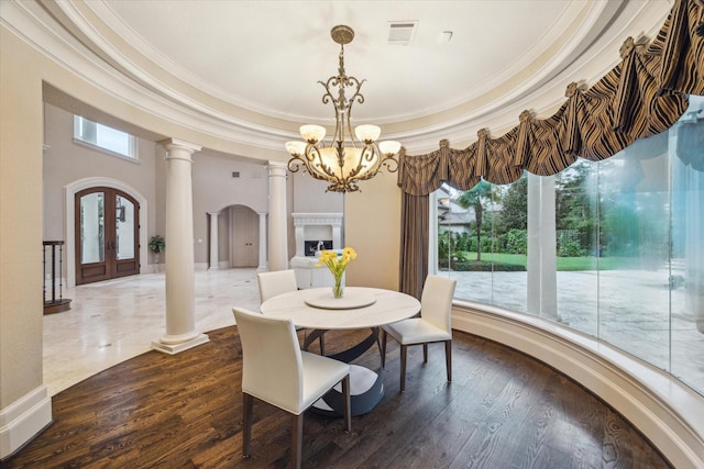 6 Kings Lake Estates Blvd, Kingwood, TX 77346 - dining area featuring a chandelier, ornate columns, ornamental molding, plenty of natural light, and wood finished floors