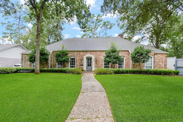 327 Cinnamon Oak Ln, Houston, TX 77079 - view of front of property with a front lawn, brick siding, a chimney, and roof with shingles