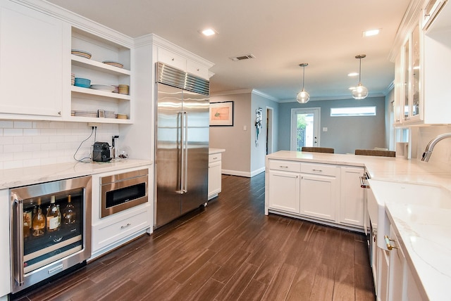 327 Cinnamon Oak Ln, Houston, TX 77079 - kitchen featuring built in refrigerator, beverage cooler, crown molding, a peninsula, and dark wood-style flooring