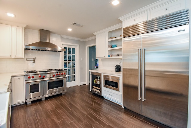 327 Cinnamon Oak Ln, Houston, TX 77079 - kitchen featuring built in appliances, wall chimney range hood, wine cooler, ornamental molding, and tasteful backsplash
