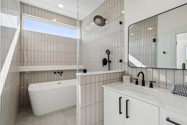 3219 Brewster St, Houston, TX 77026 - bathroom featuring tile walls, a freestanding bath, vanity, tiled shower, and tile patterned floors