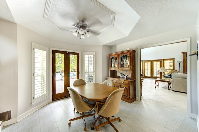 15817 Honolulu St, Jersey Village, TX 77040 - dining space with french doors, a ceiling fan, a textured ceiling, and a raised ceiling