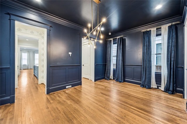 727 Tulane St, Houston, TX 77007 - empty room with a decorative wall, crown molding, light wood-type flooring, and wainscoting