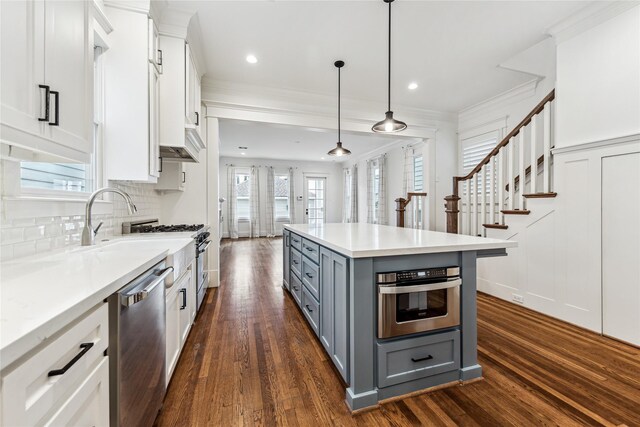 727 Tulane St, Houston, TX 77007 - kitchen with gray cabinets, appliances with stainless steel finishes, dark wood-type flooring, white cabinets, and ornamental molding